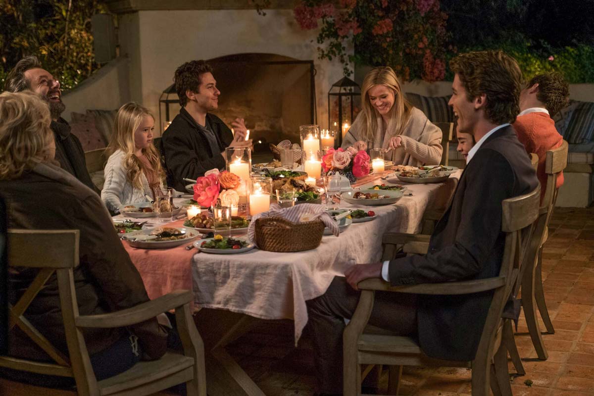 The cast of HOME AGAIN (2017) in an outdoor dinner scene