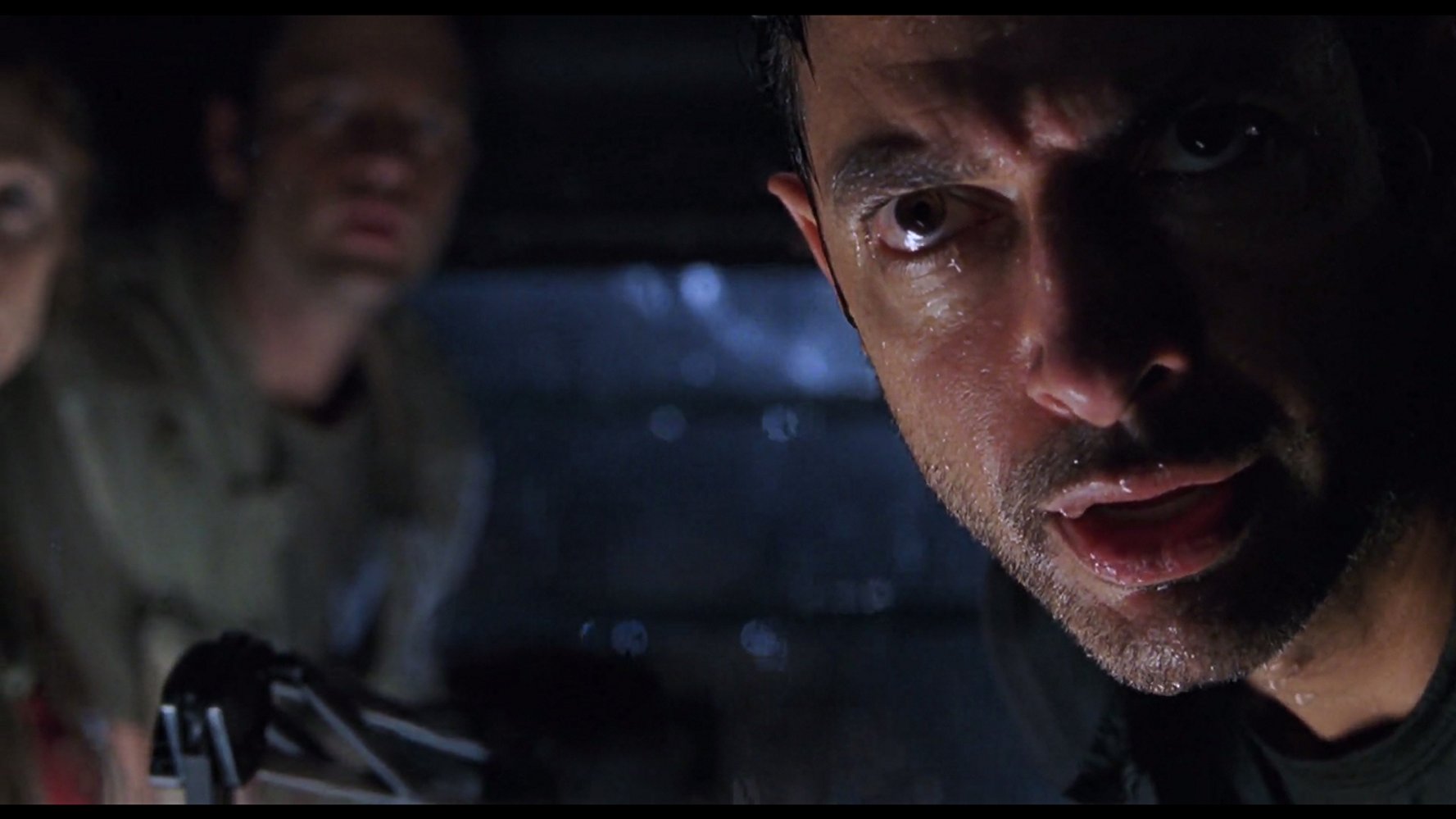 A rain-soaked Jeff Goldblum stares down a T-Rex in THE LOST WORLD: JURASSIC PARK (1997)