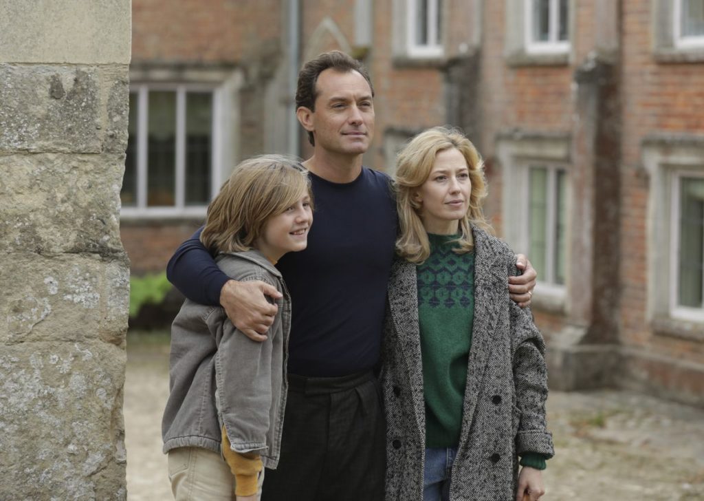 Charlie Shotwell, Jude Law, and Carrie Coon pose outside of their new home for a photograph in THE NEST (2020)