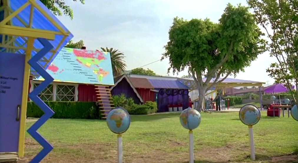 A house with a map on its roof and globes lining its streets in COOL AS ICE (1991)