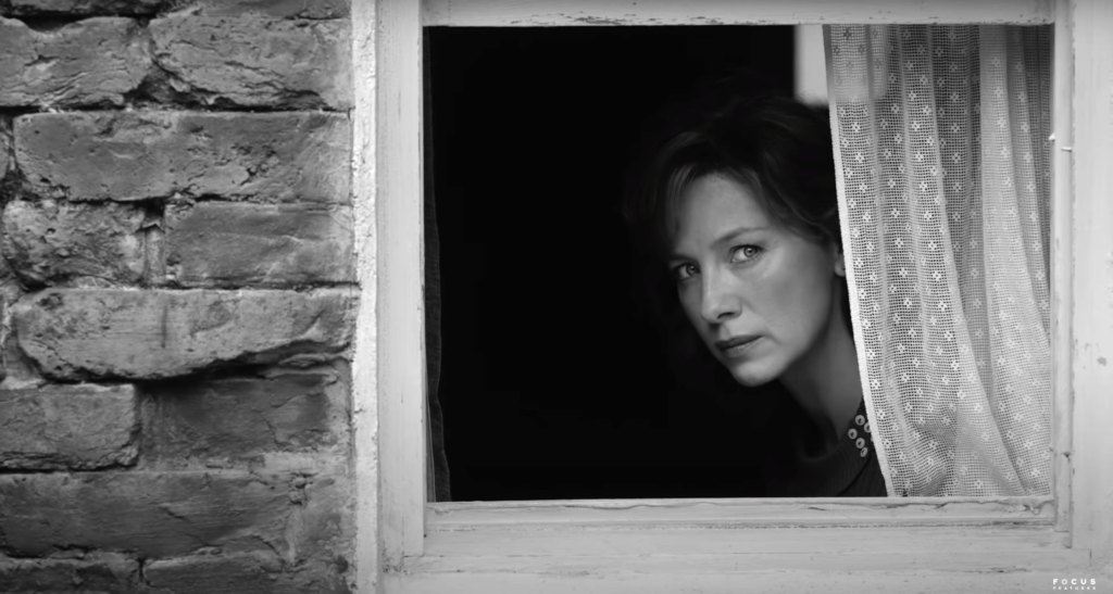 Caitriona Balfe looks through a window in BELFAST (2021)