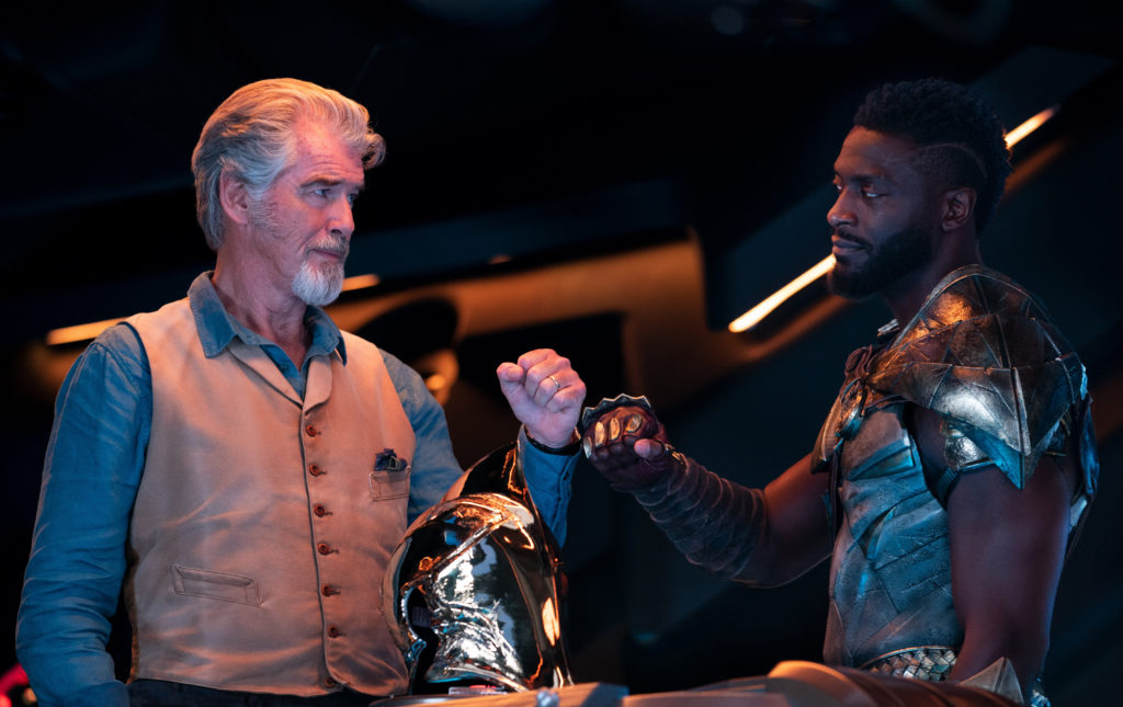 Pierce Brosnan and Aldis Hodge fist bump in BLACK ADAM (2022)