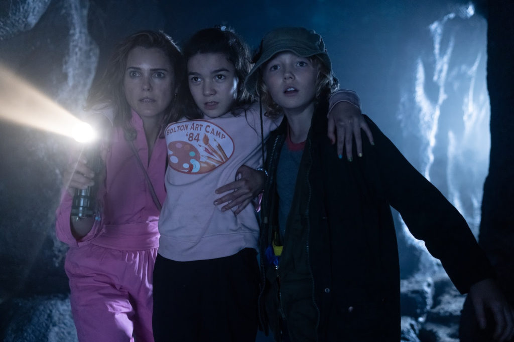 Keri Russell, Brooklynn Prince, and Christian Convery investigate a cave in COCAINE BEAR (2023)