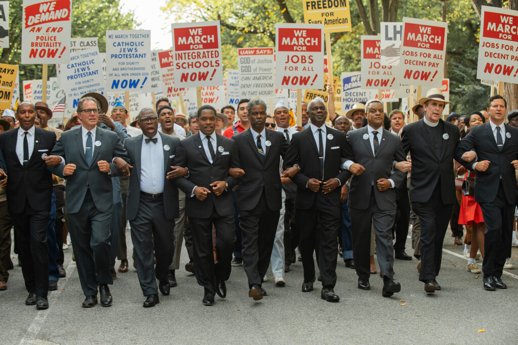 Rustin. (L to R) Michael Potts as Cleve Robinson, Aml Ameen as Martin Luther King Jr., Chris Rock as NAACP Exec. Dir. Roy Wilkins, Glynn Turman as A. Philip Randolph and Kevin Mambo as Whitney Young in Rustin. Cr. David Lee/Netflix © 2023